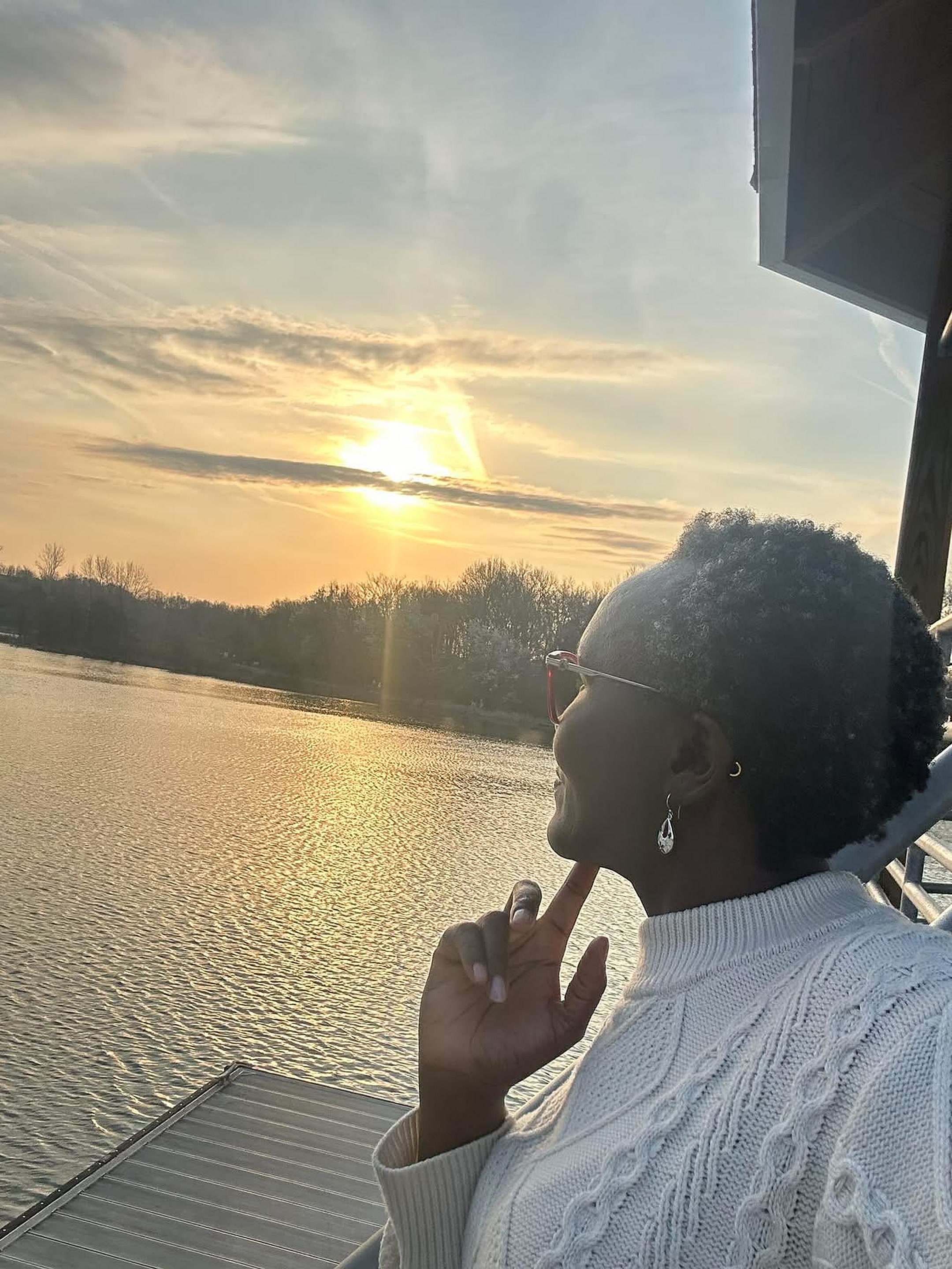 Kemunto Achira, founder of Shalom Wellness Network, watching the sunset over a lake